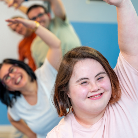 Young female with down syndrome exercising with friends